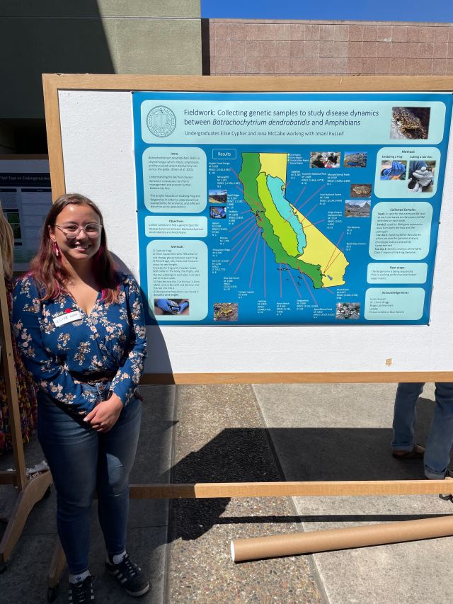 Photo of Elise standing next to their poster